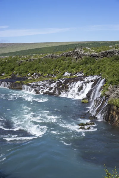 Cascada de Hraunfossar emergiendo bajo el campo de lava Hallmundarhraun —  Fotos de Stock