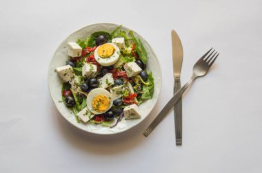 Salata, bıçak, çatal, beyaz arka planda izole edilmiş beyaz tabak.