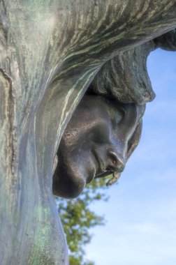 Yüzünü ve kolunun bir kısmını gösteren bir heykel parçası.