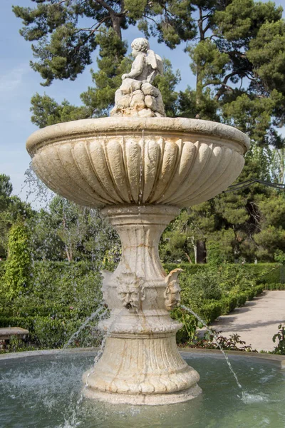 ornamental fountain with a small angel and faces expelling jets of water