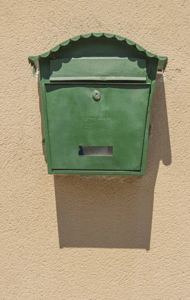 绿色邮箱将阴影投射在水泥墙背景上 — 图库照片
