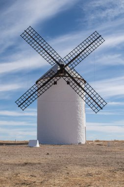 A windmill in La Mancha, isolated on land in Campo de Criptana, Ciudad Real province, Spain.