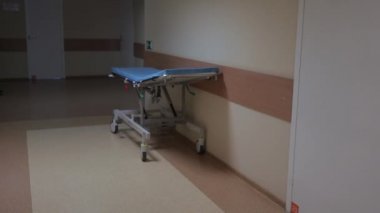 Hastane koridorunda tekerlekler üzerinde tıbbi yatak.