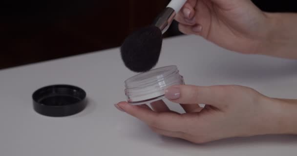 Макіяж художник кладе порошок для обличчя на пензлик для макіяжу — стокове відео