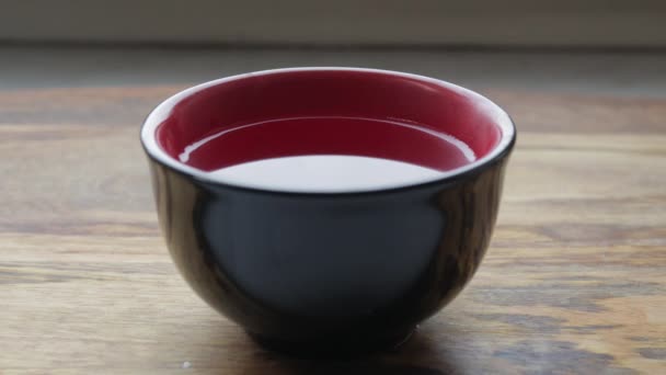 Hot porcelain cup of tea on a wooden table. — Stock Video