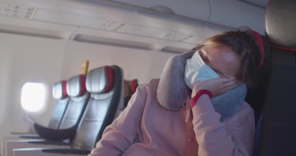 Senhora com azul máscara facial descartável dorme na cadeira de avião — Vídeo de Stock