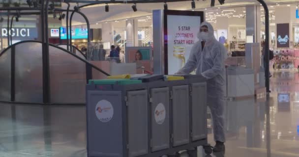 ISTANBUL, TURQUIA - Fevereiro 20, 2021: Janitor de terno e máscara transporta latas de lixo ao longo do aeroporto — Vídeo de Stock