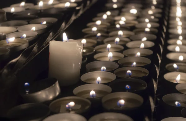 Rows of burning candles inside a church — Stock Photo, Image