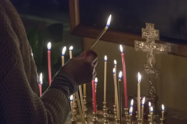 Woman lighting prayer candle — Stock Photo, Image