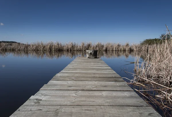 Jetée ou jetée en bois dans un barrage d'eau bleue Images De Stock Libres De Droits