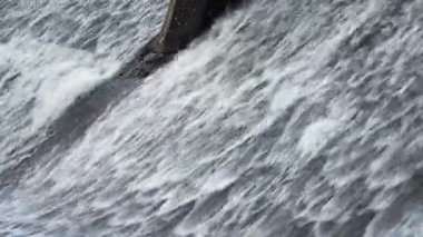 Kükreyen bir şelalede, beton bir şelalenin üzerinde dalgalanan su dokulu akışı ve köpüklü türbülansı doğanın hareket halindeki ham enerjisini ortaya çıkarıyor..