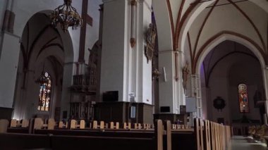 Riga, Letonya - 2 Mayıs 2024. Riga Katedrali 'nin içindeki panoramik manzara. Bir çocuk koridorda yürüyor, yüksek sütunlar ve kubbeli tavanlarla çerçevelenmiş. Tarihi ve ruhani atmosfer.