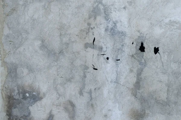 gray concrete garage wall with spots of black paint abstract bac