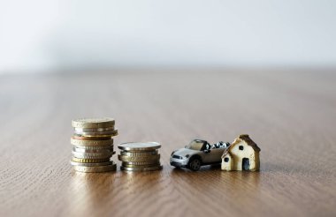 Küçük plastik ev arabası ve bozuk paralarla emlak konsepti