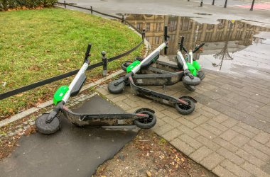 Terk edilmiş kirli bir limon scooter 'ı bir caddenin zemininde yatıyor. 