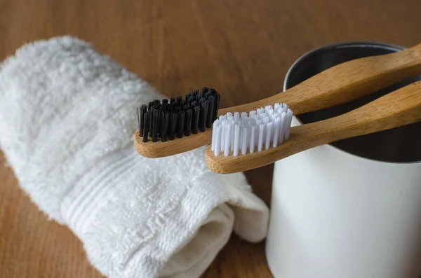 Δύο Οδοντόβουρτσες Μπαμπού Λευκή Πετσέτα Ξύλινο Φόντο — Φωτογραφία Αρχείου