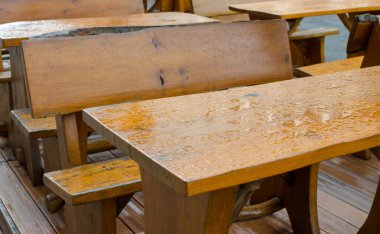 Dışarıdaki ahşap masalar ve yağmurdan sonra suyla kaplı koltuklar. O