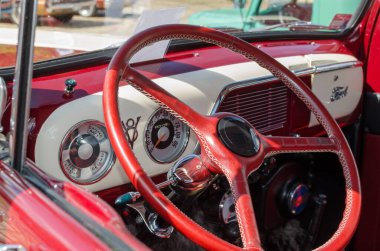 WROCLAW, POLAND - 11 Ağustos 2019: Amerikan otomobilleri 1951 model Ford F-100 kamyonet kırmızı ve beyaz renkli. İç gösterge paneli ve direksiyona yakın çekim.