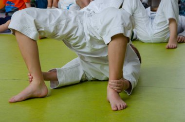 Karate eğitimi. Sarı kemerli çocuklar düz duruyor ve egzersiz için bekliyorlar.