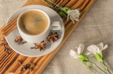 Bir fincan espresso, tarçın çubukları, anis yıldızları ve beyaz karanfiller. Günaydın konsept. 