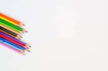 Beyaz kağıt arka planda renkli kalemler. Metin için alanı kopyala