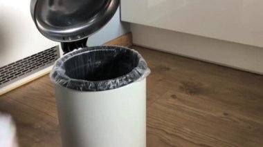 Kadının eli kullanılmış bezleri evdeki çöp kutusuna tek tek koydu..