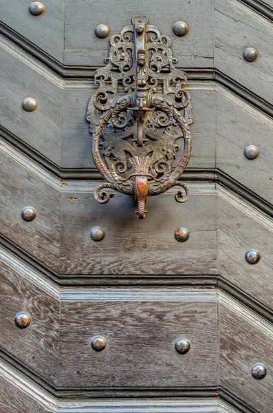Old decorative handle, close up, at a medieval door — стоковое фото