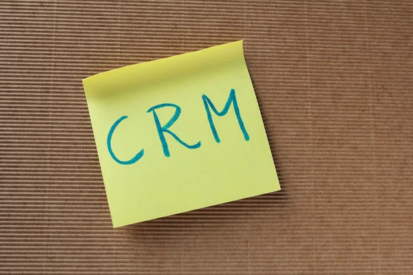 Texto CRM (Gestión de relaciones con el cliente) en nota adhesiva amarilla — Foto de Stock