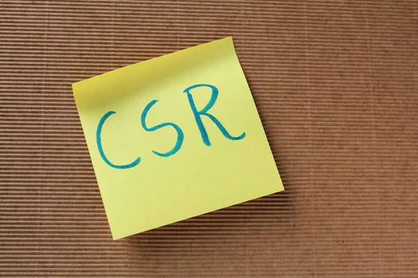 Texto CSR (Responsabilidad Social Corporativa) en nota adhesiva amarilla — Foto de Stock