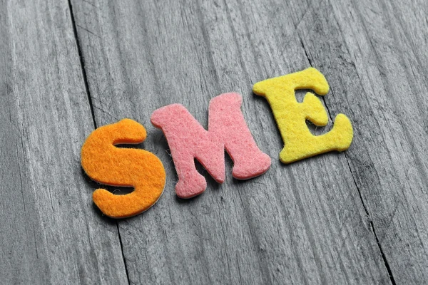 SME (små medelstora företag) akronym på trä bakgrund — Stockfoto