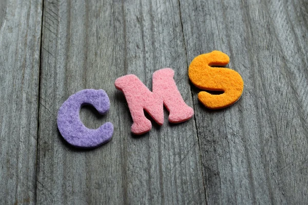 Acronyme CMS (Content Management System) sur fond bois — Photo