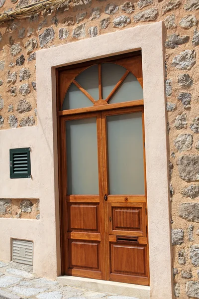 石の壁、地中海スタイルの茶色の木製のドア — ストック写真
