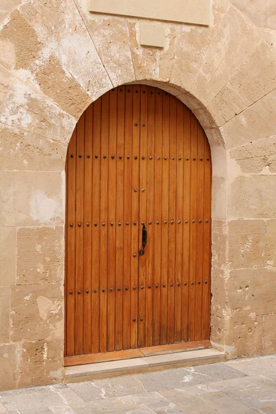 Wooden door in stone wall, mediterranean style — Stock Photo, Image