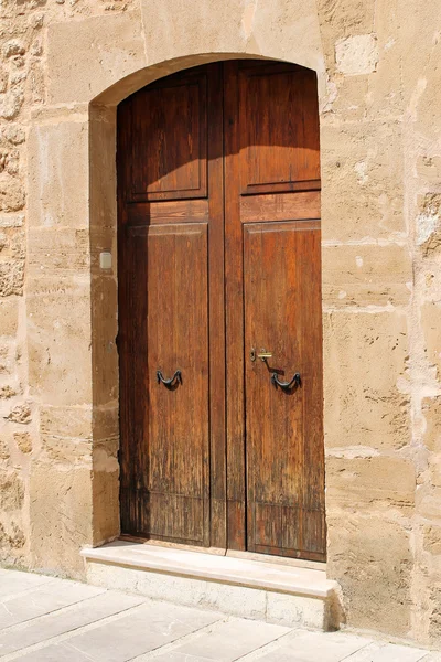 在石头墙，地中海风格的木制门 — 图库照片