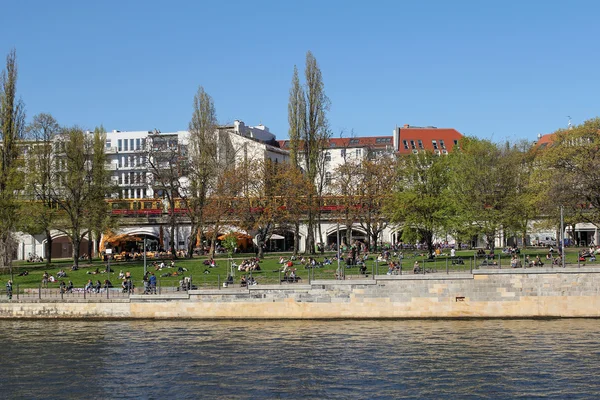 BERLIN, GERMANY, APRIL 21, 2016: people resting on the grass by the river Spree in Berlin at sunny day. — Stock Photo, Image