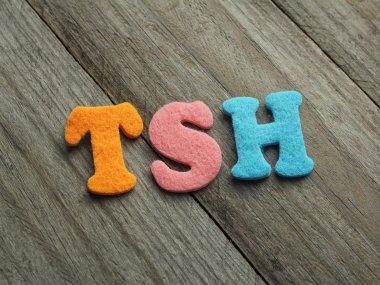 TSH (Thyroid-stimulating hormone) acronym on wooden background clipart