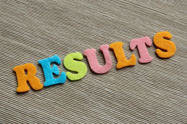 Resultados palabra hecha con letras de fieltro de colores — Foto de Stock