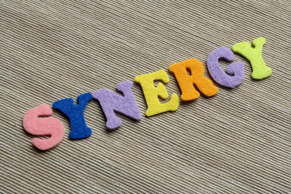 Palavra sinergia feita com letras coloridas de feltro — Fotografia de Stock