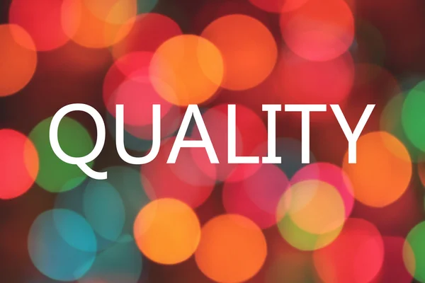 Quality word on colorful blurred bokeh background — Stock Photo, Image