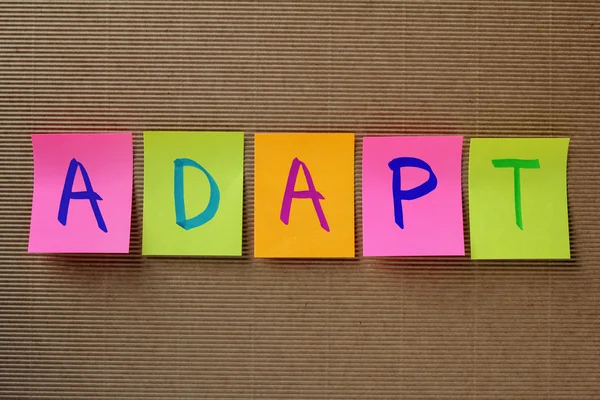 Adaptar palabra en notas pegajosas coloridas — Foto de Stock