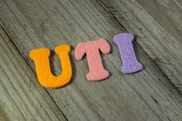 UTI (Urinary Tract Infection) acronym on wooden background — Stock Photo, Image