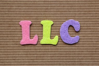 LLC (Limited Şirket) kısaltma karton arka plan üzerinde