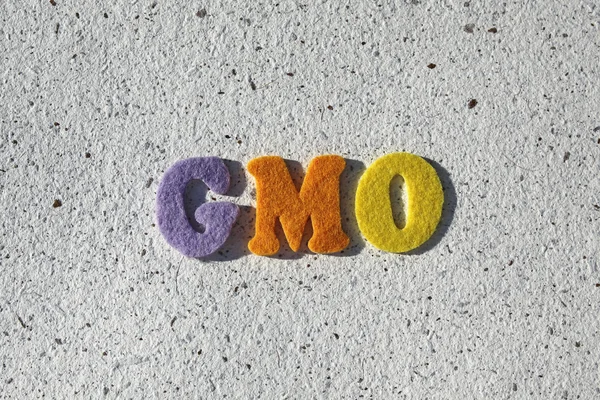 GMO (Genetically Modified Organisms) acronym on handmade paper texture