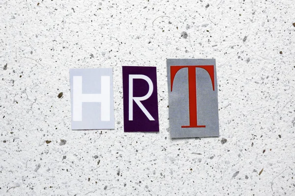 HRT (hormonalnej terapii zastępczej) skrót wycięte z gazety na tekstury biały papier czerpany — Zdjęcie stockowe