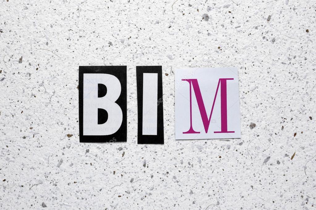 BIM (Building Information Modeling) acronym cut from newspaper on white handmade paper texture