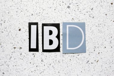 IBD (Inflammatory Bowel Disease) acronym cut from newspaper on white handmade paper texture clipart