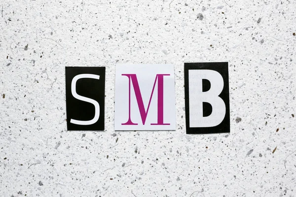 SMB (kis-közepes méretű üzleti) rövidítés vágott újság fehér merített papír textúra — Stock Fotó