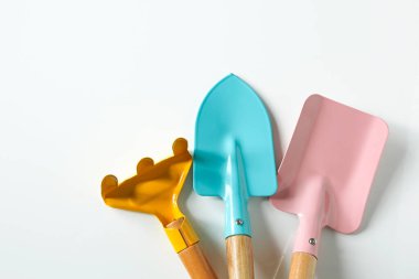 Beyaz parlak arkaplan üzerinde sevimli renkli bahçe araçları bileşimi