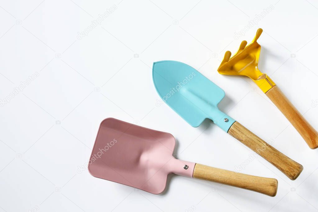 composition of cute colorful gardening tools on white shiny background