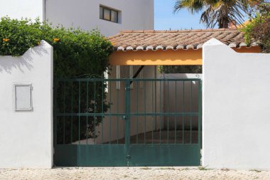 Beyaz duvarda yeşil metal kapı